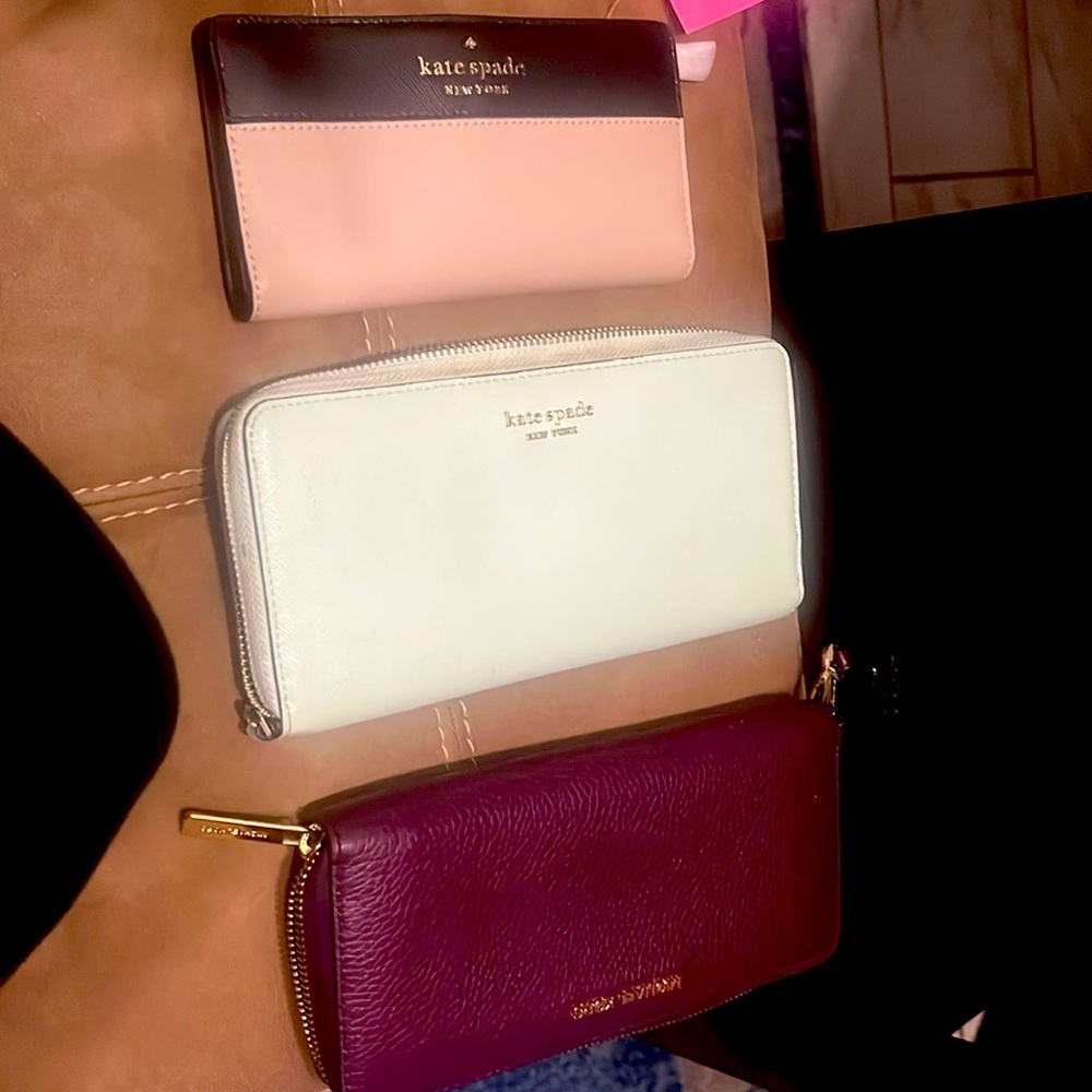 3 brand name wallets one with a tag